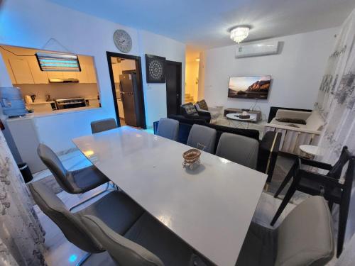 رويال فيلا بمسبح خاص في King Abdullah Economic City: غرفة معيشة مع طاولة وكراسي بيضاء