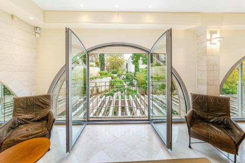 2 stoelen in een kamer met een groot raam bij David Citadel Hotel Private Luxury Suites in Jeruzalem