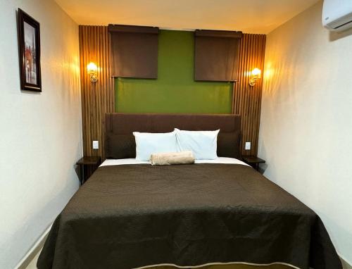 sypialnia z dużym łóżkiem i zieloną ścianą w obiekcie Royal Madero Inn Express w mieście Tampico