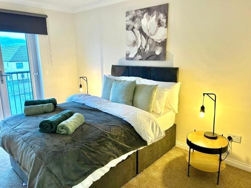 Central Cosy Riverview Apartment 2 bed, 2 bath, Free Parking / WiFi في إينفيرنيس: غرفة نوم بسرير كبير وطاولة