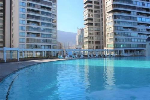uma grande piscina no meio de alguns edifícios em Frente al mar hasta 10 personas em Iquique