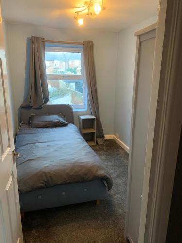 Habitación pequeña con cama y ventana en North house 3 bed home Sleeps up to 5 en Darlington