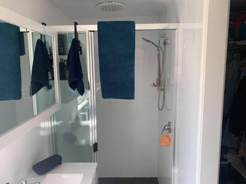 ein weißes Bad mit einer Dusche und einem Waschbecken in der Unterkunft Inner City Boutique Home. Pet and Family Friendly! in Canberra