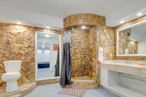 een badkamer met stenen muren, een toilet en een douche bij Comfortable Alabama Apartment Pets Welcome! in Jackson