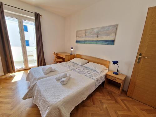 sypialnia z łóżkiem z dwoma ręcznikami w obiekcie APARTMENTS JOSIPA w Bašce