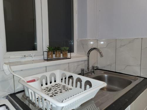 a kitchen with a sink and a dish drying rack at Lovely Coventry Home - Ideal for Business, Contractors, Families, Relocators mins walk to City Centre and University in Wyken
