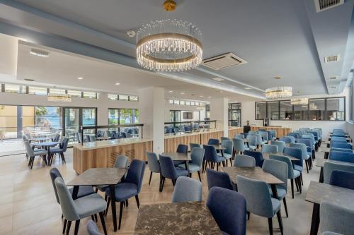 a dining room with tables and chairs and a bar at Depadans Hotela TALIA in Igalo