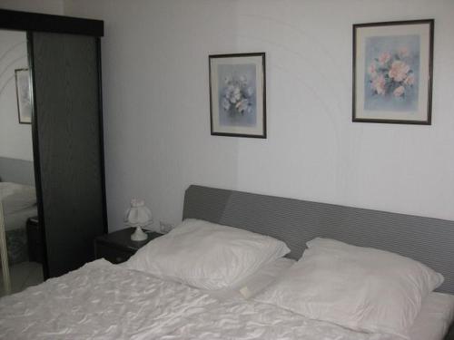 ドゥネンにあるDallacker 01の壁に2枚の写真が飾られたベッドルームのベッド1台