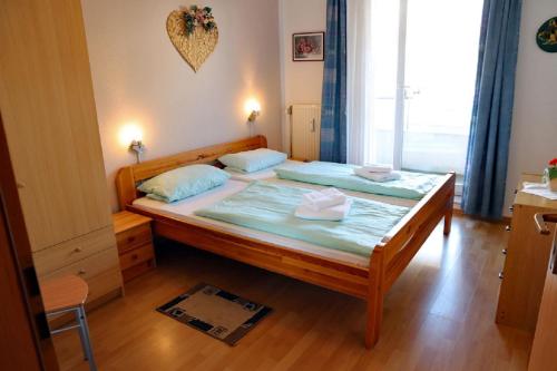 - une chambre avec un grand lit en bois et des oreillers bleus dans l'établissement Oasis 03, à Cuxhaven