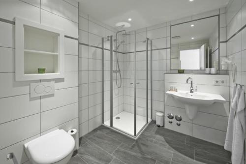 een witte badkamer met een douche en een wastafel bij Op de Geest 09 in Cuxhaven