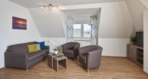 uma sala de estar com um sofá e duas cadeiras em Op de Geest 15 em Cuxhaven