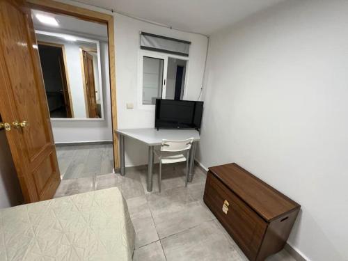 een kleine kamer met een tafel en een televisie bij Casa Paula in Ceuta