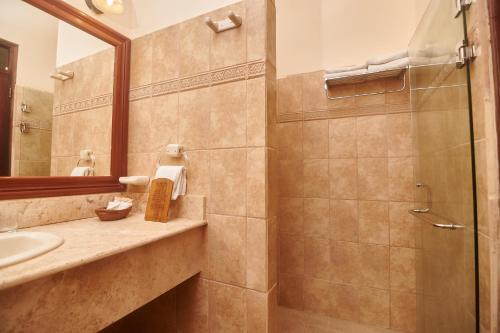 a bathroom with a shower and a sink and a mirror at Hotel Plaza Colon - Granada Nicaragua in Granada