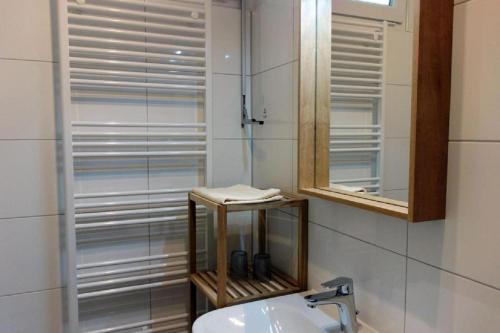 a bathroom with a shower and a sink and a mirror at Herzmuschel in Döse