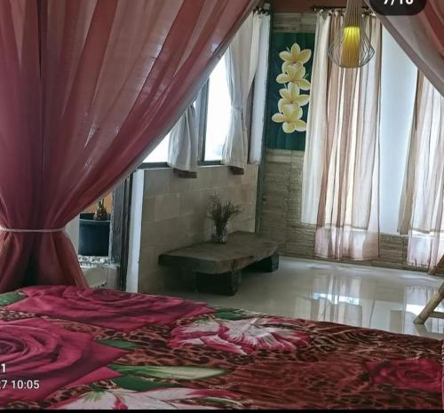 a bedroom with a bed and a table and curtains at Rara Villas Lombok in Senggigi 