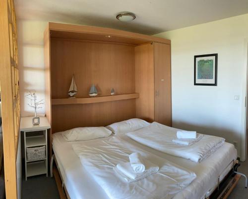 een slaapkamer met een groot wit bed met een houten hoofdeinde bij Residenz 18 in Duhnen