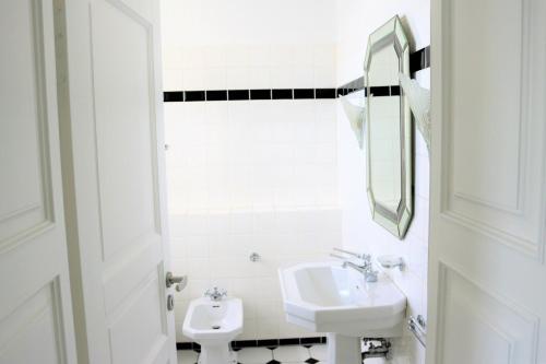 ein weißes Badezimmer mit einem Waschbecken und einem Spiegel in der Unterkunft Nordsee 03 in Duhnen