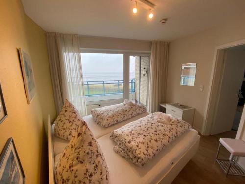una camera con due letti e una finestra con vista sull'oceano di Seehütte 04 a Duhnen