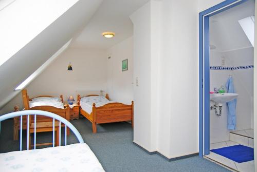 baño con 2 camas y lavabo en una habitación en Oasis 09, en Cuxhaven