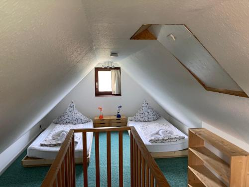 two beds in a attic room with a staircase at Haus Muschelnest in Sahlenburg