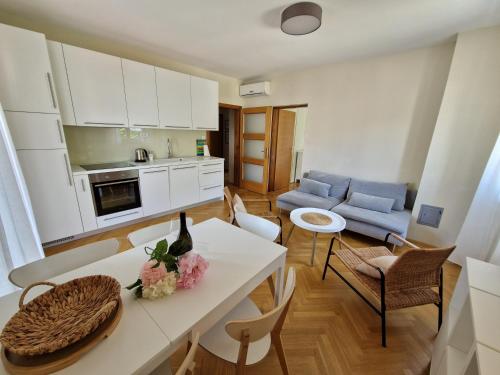 kuchnia i salon ze stołem i krzesłami w obiekcie APARTMENTS JOSIPA w Bašce