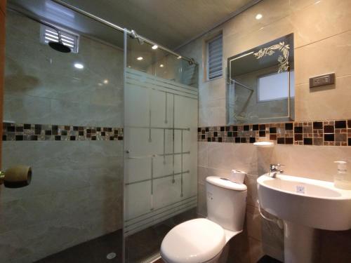 e bagno con servizi igienici, lavandino e doccia. di Hotel Casa Baquero a Bogotá