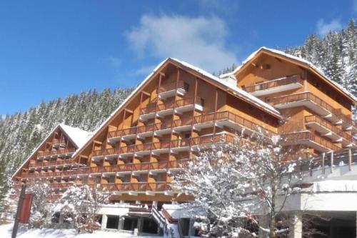 a large building with snow on the ground at Chandonnelles 8 in Mussillon