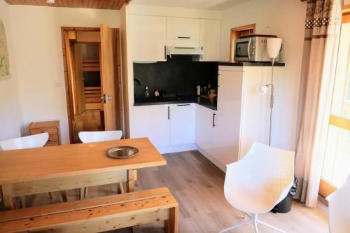a kitchen with a wooden table and white cabinets at Chandonnelles 8 in Mussillon