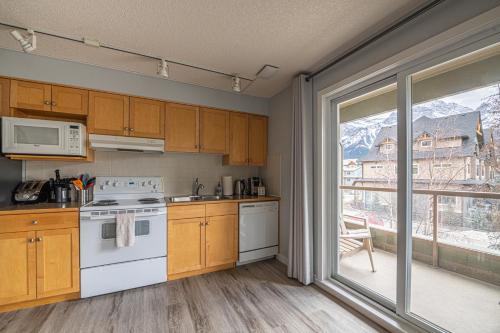 a kitchen with a white stove top oven next to a window at Windtower Lodge - Canmore in Canmore