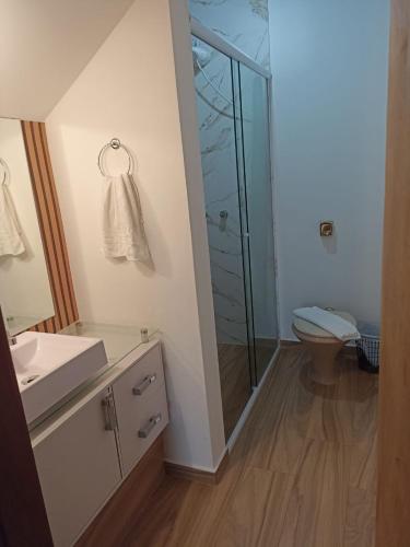 a bathroom with a toilet and a glass shower at Vilarejo da Esperanza in Campos do Jordão