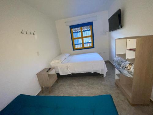 um pequeno quarto com uma cama e uma janela em Hotel Don Blas Jardín em Jardín