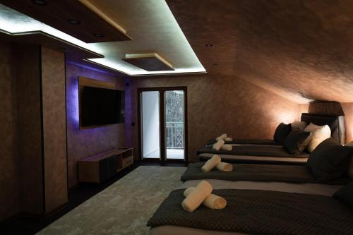 um quarto com quatro camas num quarto com uma televisão em Motel Lašva em Zenica