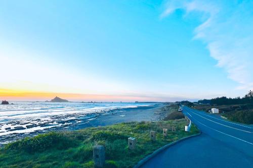 a road next to a beach with the sunset at Pacific Princess in Crescent City