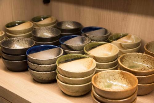 a bunch of bowls sitting on a wooden shelf at Richmond Hotel Utsunomiya-ekimae Annex in Utsunomiya
