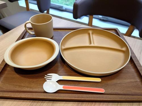 two empty plates and a spatula on a wooden tray at Richmond Hotel Utsunomiya-ekimae Annex in Utsunomiya