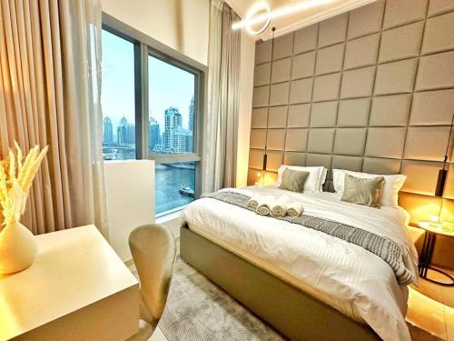 een slaapkamer met een groot bed en een groot raam bij Your Cosy Marina Retreat in Dubai