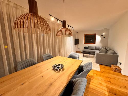 a living room with a wooden table and a couch at Dreamy Apartment by Lake Haider and Lake Reschen Uniting Luxury, Nature and Relaxation in San Valentino alla Muta