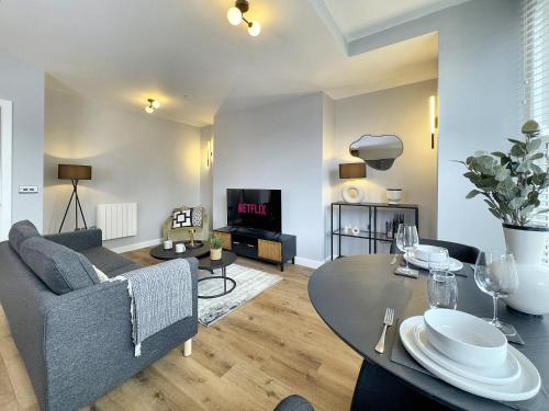a living room with a couch and a table at Harrogate House Apt 2 - Stylish Central Flat in Harrogate