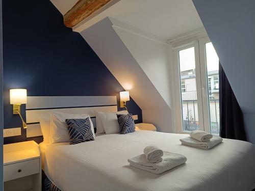 1 dormitorio con 1 cama grande y toallas. en Hôtel Apollo Opéra, en París