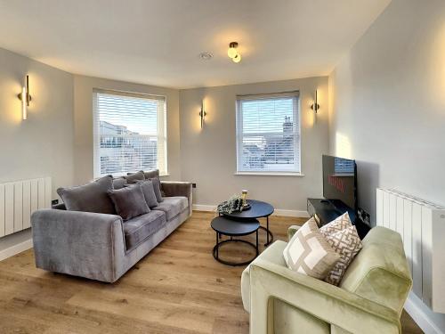 a living room with a couch and a table at Harrogate House Apt 4 - Cheltenham Parade Loft in Harrogate