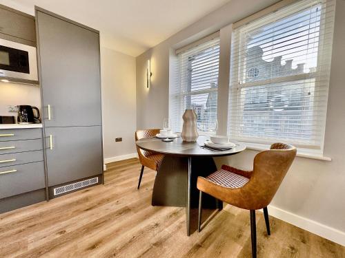 a kitchen and dining room with a table and chairs at Harrogate House Apt 4 - Cheltenham Parade Loft in Harrogate