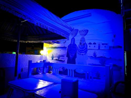 a night view of a patio with blue lights at Gamal Robob Nubian Guest House in Aswan