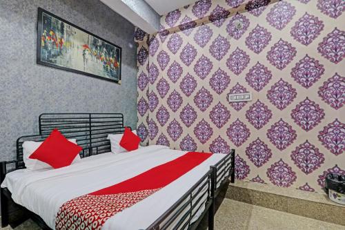 a bedroom with a bed with red pillows on it at OYO Flagship MH Palace in Lucknow