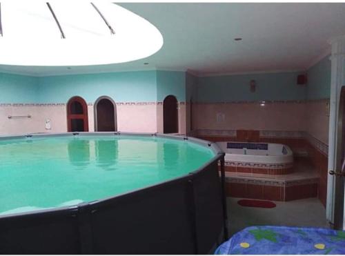 a large swimming pool with a tub in a room at Aparta Hotel Plenitud in Palmira