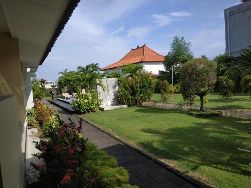 a house with a garden and a yard with flowers at Dega Gardens in Canggu