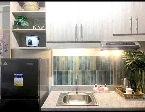 a kitchen with a sink and a refrigerator at Tehillah Residences in Bacolod
