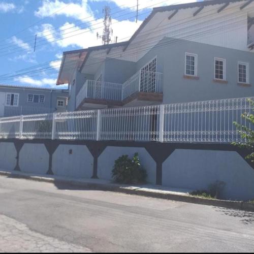 a white house with a white fence on the side of it at Vilarejo da Esperanza in Campos do Jordão