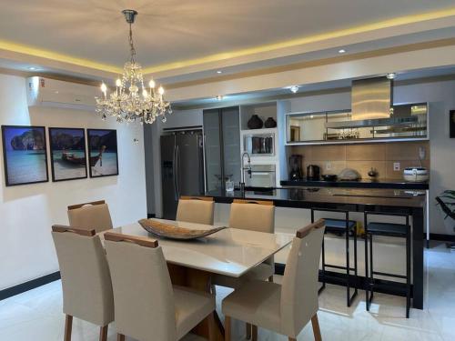 a dining room and kitchen with a table and chairs at Apt de luxo na Praia do Morro c/ vista para o mar in Guarapari