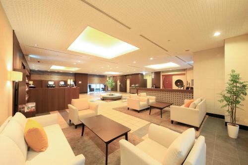 - un hall avec des meubles blancs et une salle d'attente dans l'établissement Richmond Hotel Utsunomiya-ekimae, à Utsunomiya