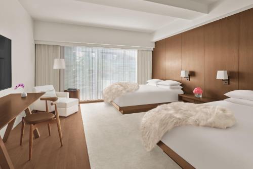 a hotel room with two beds and a desk at The Tokyo EDITION, Ginza in Tokyo